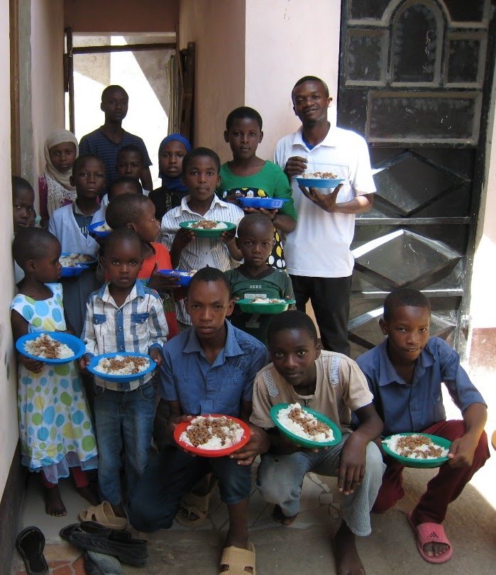 children-holding-plates-of-food A group of children holding plates of beans and rice